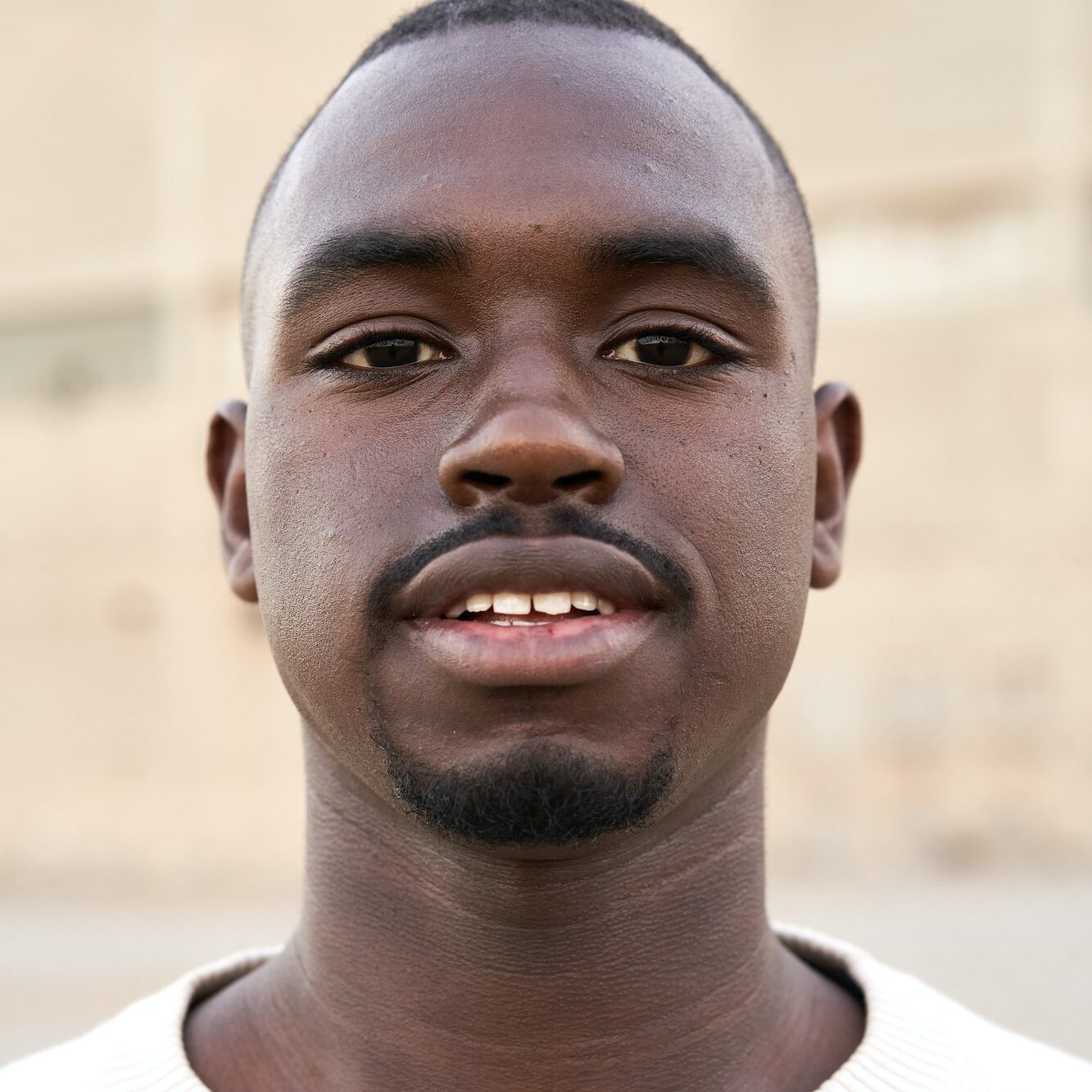 Young african man looking at camera standing outdoors.